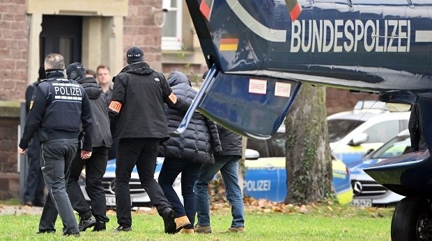 Eine Person (2.v.r.) wird von Polizisten aus einem Hubschrauber gebracht. Die Bundesanwaltschaft hat im Dezember mehrere Menschen aus der sogenannten "Reichsbürgerszene" im Zuge einer Razzia festnehmen lassen.
