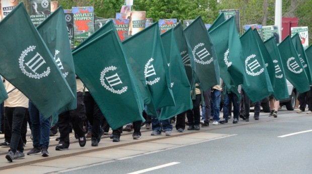 Teilnehmer eines rechten Aufmarsches der Partei "Der dritte Weg" gehen am 01.05.2019 eine Straße entlang