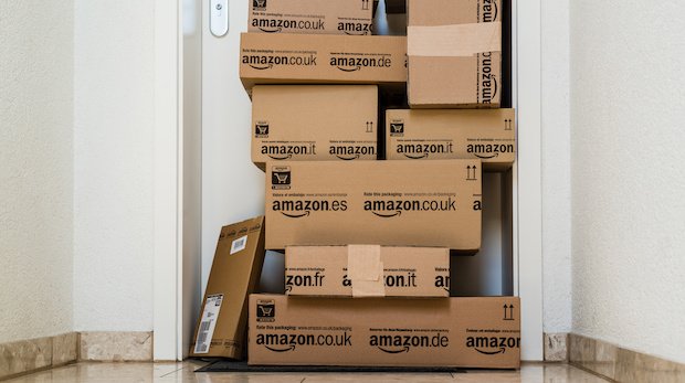 Pakete mit Amazon-Logo stapeln sich vor einer Wohnungstür