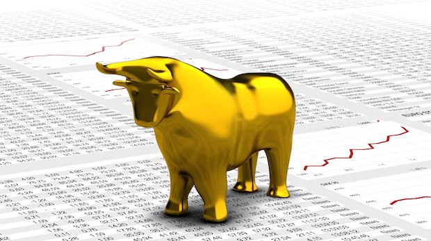 Börsenkurse auf Papier mit einem goldenen Bullen
