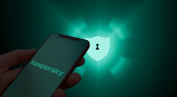 Ein Smartphone mit Kaspersky-Logo vor einem grünem Hintergrund