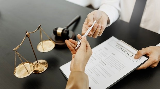 Ein Rechtsanwalt unterschreibt einen arbeitsrechtlichen Vertrag