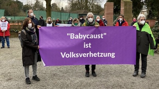 Menschen halten ein Plakat mit "'Babycaust' ist Volksverhetzung" hoch.