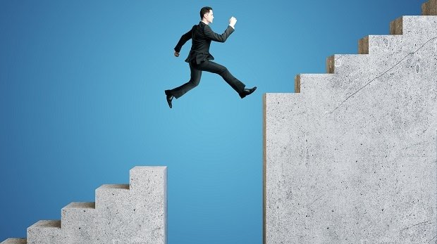 Ein Mann springt auf die nächste Stufe einer Treppe
