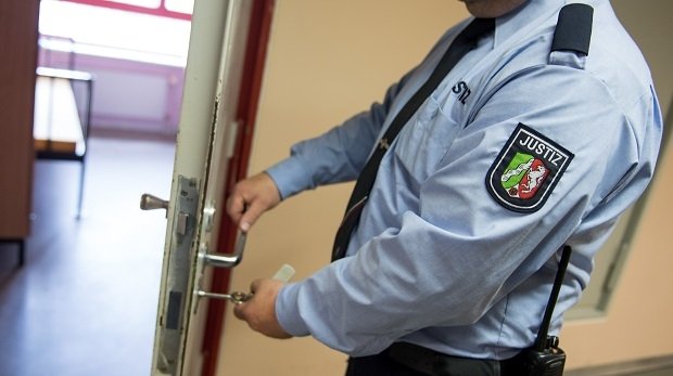Ein Justizvollzugsbeamter schließt am 28.07.2014 in der Justizvollzugsanstalt Gelsenkirchen (Nordrhein-Westfalen) eine Tür.