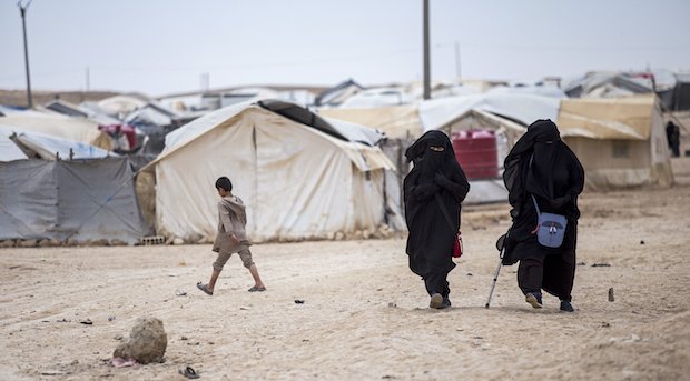 Women walk in the al-Hol camp that houses some 60,000 refugees, including families and supporters of the Islamic State group, many of them foreign nationals, in Hasakeh province, Syria, Saturday, May 1, 2021.