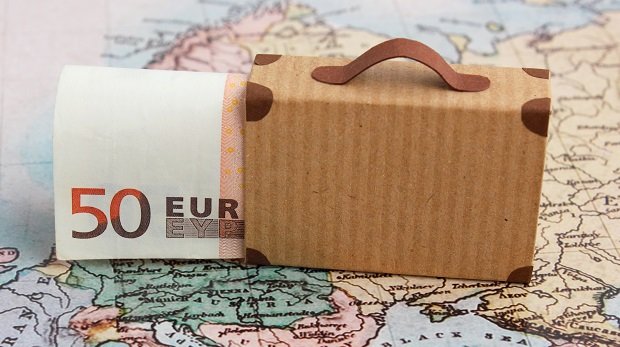 Koffer mit Euroschein auf Weltkarte