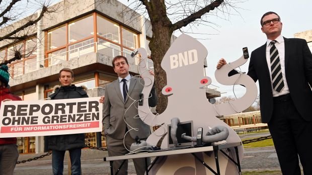 Christian Mihr (2.v.l), Geschäftsführer von Reporter ohne Grenzen, und Ulf Buermeyer, Vorsitzender der Gesellschaft für Freiheitsrechte, stehen vor dem Bundesverfassungsgericht an einer symbolhaften Krake, auf der die Buchstaben BND angebracht sind.