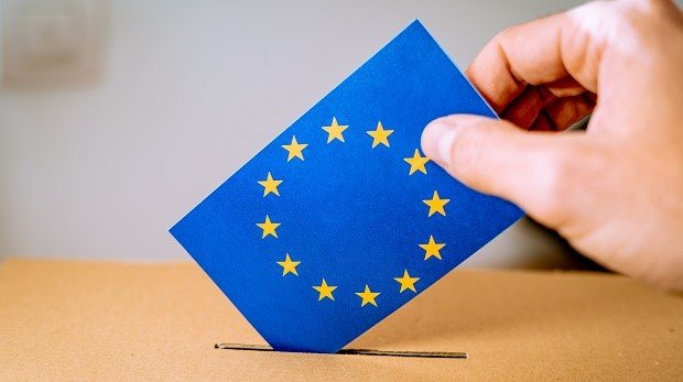 Briefumschlag mit Europa-Logo wird in eine Wahlurne gesteckt