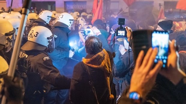 Demonstranten filmen einen Polizeieinsatz in München