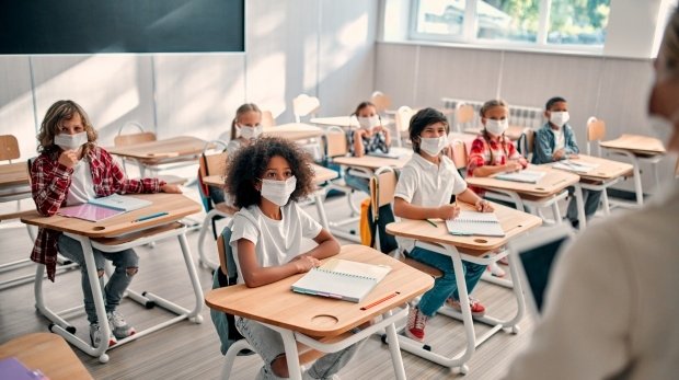 Schüler sitzen mit Masken in einem Klassenraum
