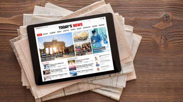 Ein Tablet mit einer Onlinezeitung auf Printausgaben
