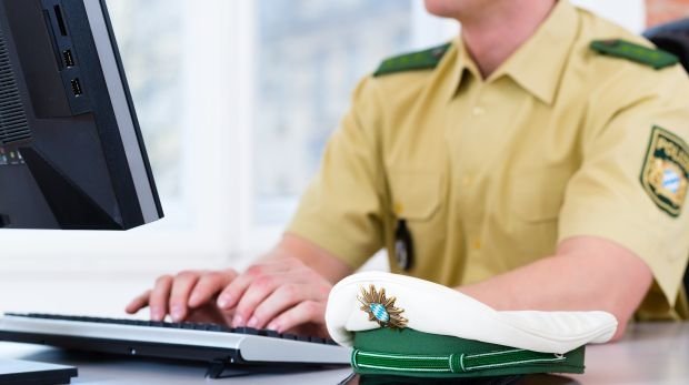 Polizist sitzt vor einem Computer