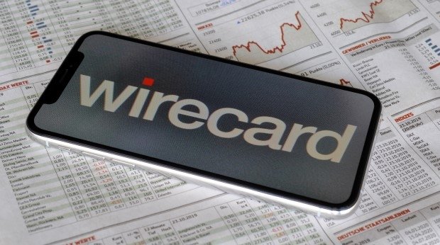 Wirecard-Logo auf einem Smartphone, das auf einer Zeitungsseite mit Börsenkursen liegt