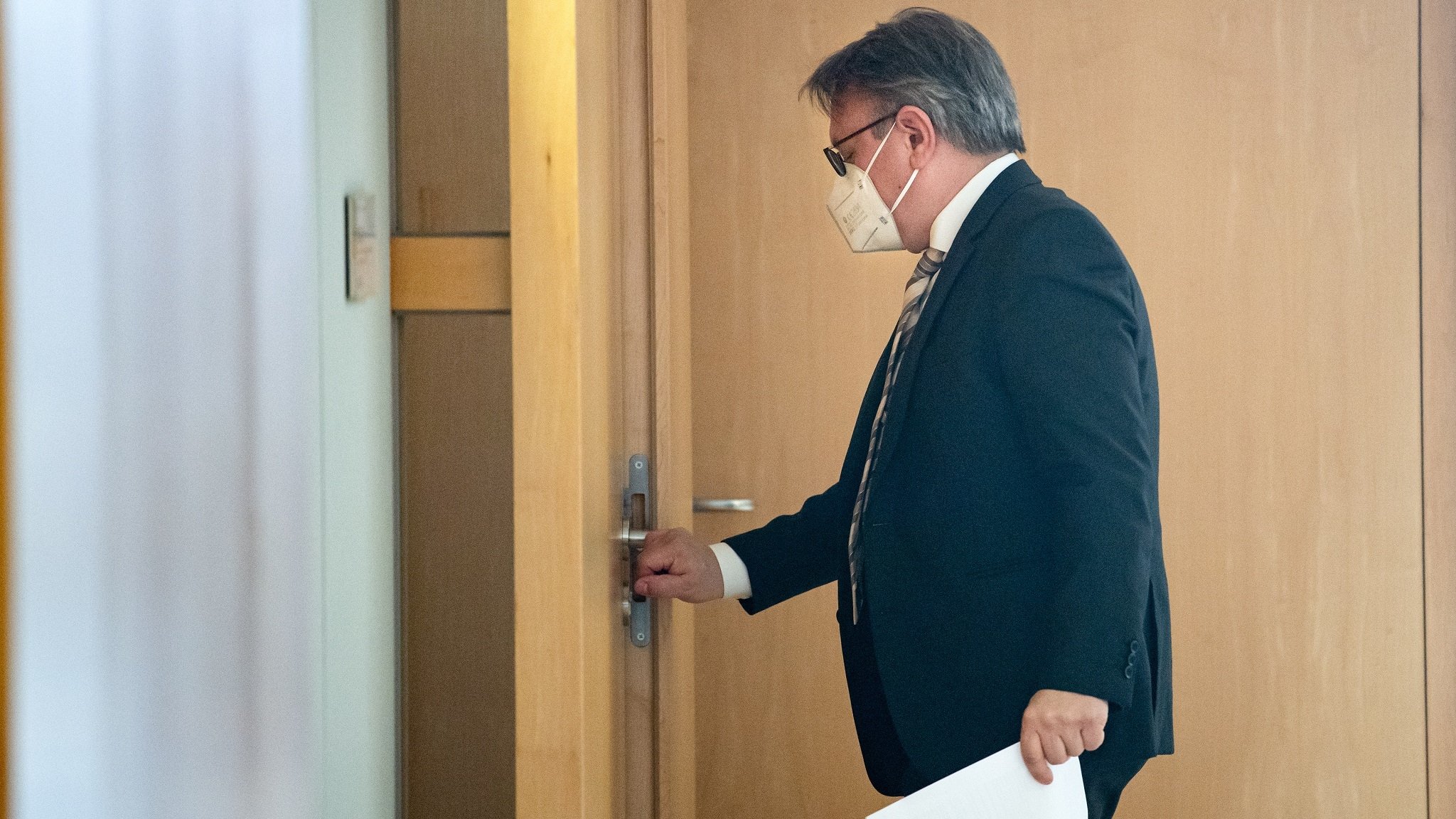 Georg Nüßlein (CSU) geht über einen Flur zu seinem Bundestagsbüro, während dieses durchsucht wird.