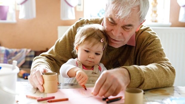 Ein Großvater malt mit seiner Enkelin.