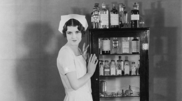 Krankenschwester lehnt an Medizinschrank