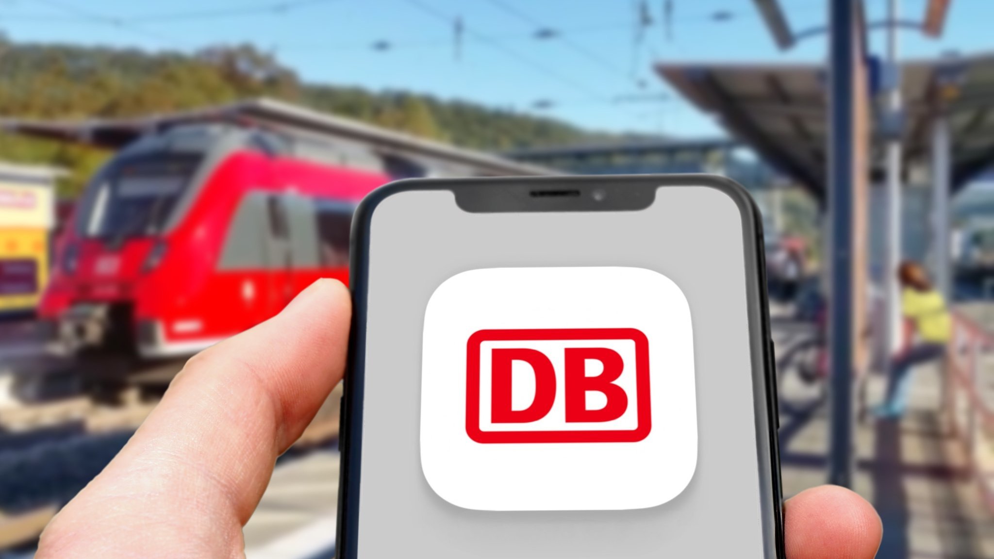 Eine Person hält ein Handy mit der DB-App