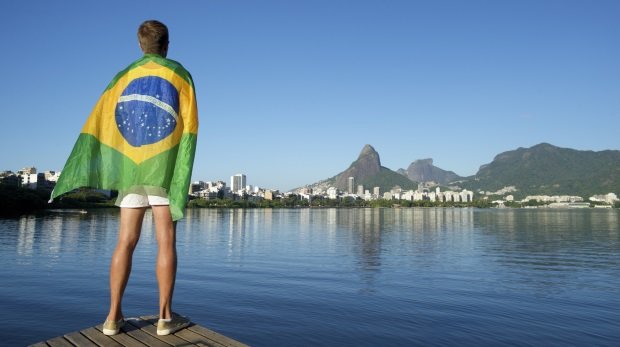 Athlet mit Flagge Brasiliens blickt auf Rio (Symbolbild)