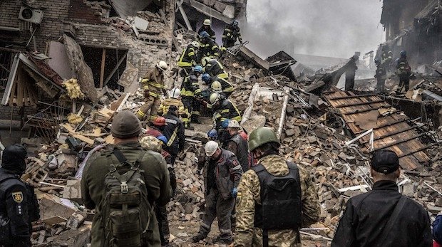 Feuerwehrleute entfernen eine Leiche aus den Trümmern eines Gebäudes nach einem russischen Raketenangriff am 10.10.2022 in Zaporizhzhia, Ukraine.
