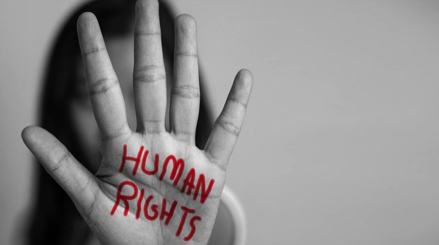 Frau, die ihre Handfläche mit den Wörtern "Human Rights" beschrieben hat.