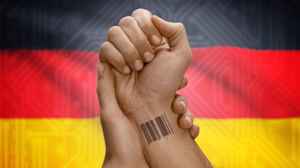 Handgelenk mit Barcode vor deutscher Flagge