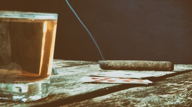 Alter Spieltisch mit Karten, Zigarrillo und Spirituosen