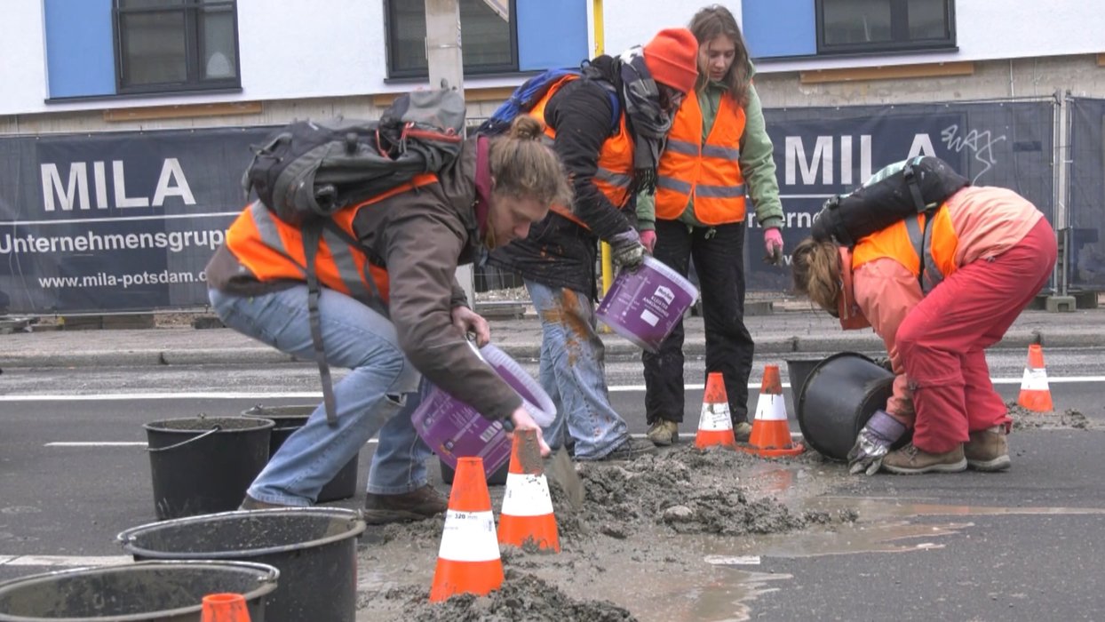 Klima-Demonstrant:innen der Gruppe "Letzte Generation" schütten in Berlin Beton auf eine Fahrbahn, 15. Februar 2023