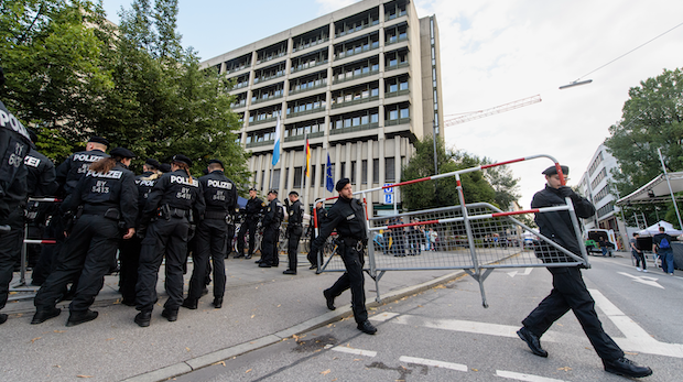 11.07.2018, Bayern, München: Polizisten stellen vor dem Oberlandesgericht in München Zäune auf.
