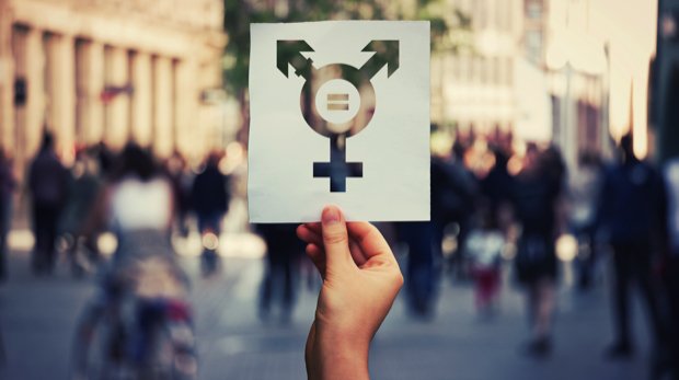 Hand hält Schild mit Transgender-Symbol in die Höhe