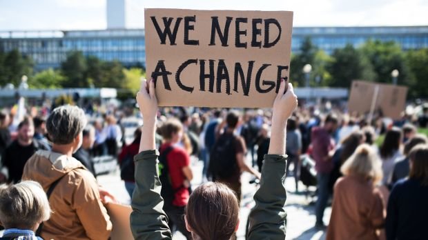 Aktivistin hält Schild auf Klima-Demo