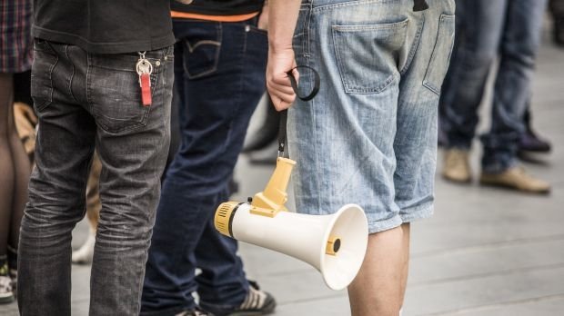 Ein Demonstrant hält ein Megafon (Symbolbild)