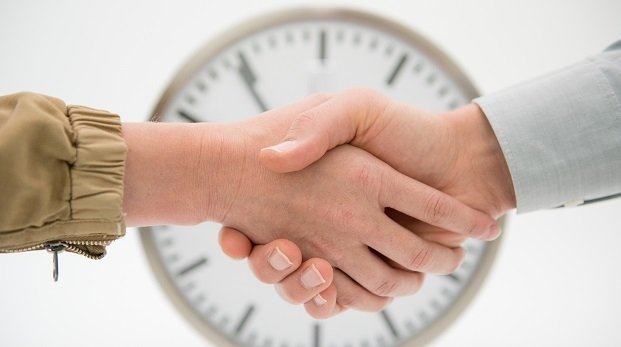 Handshake vor einer Uhr