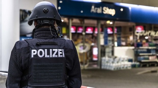 Ein Polizist sichert am frühen Morgen des 19.9.2021 die Tankstelle in Idar-Oberstein.