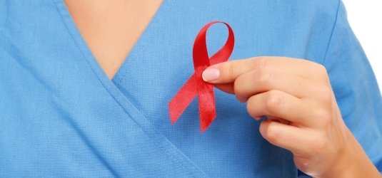 Die Rote Schleife, Symbol der Solidarität mit HIV-Infizierten und AIDS-Kranken