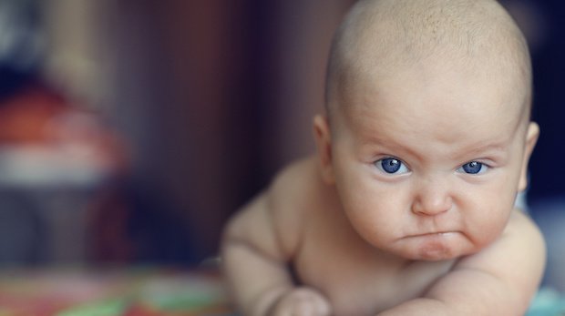 Vermutlich unzufriedenes Baby mit grimmigem Gesichtsausdruck