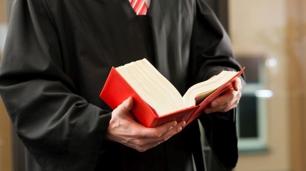 Mann in Robe mit Gesetzbuch