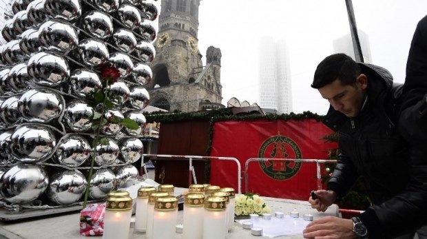 Mann zündet Kerzen am Breitscheidplatz in Berlin an