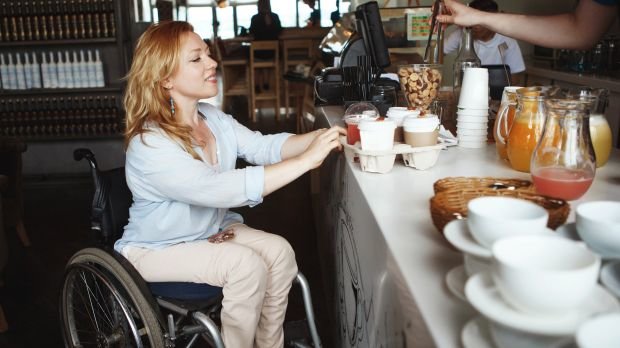 Eine Frau im Rollstuhl in einem Café (Symbolbild)