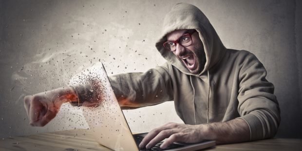 Wütender Mann schlägt durch den Laptop (Symbolbild)