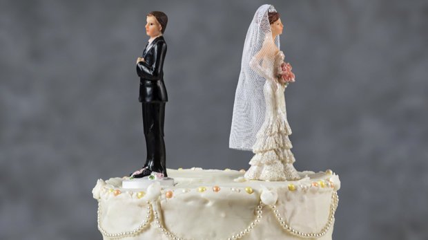 Figuren eines Brautpaars wenden sich auf einer Hochzeitstorte voneinander ab
