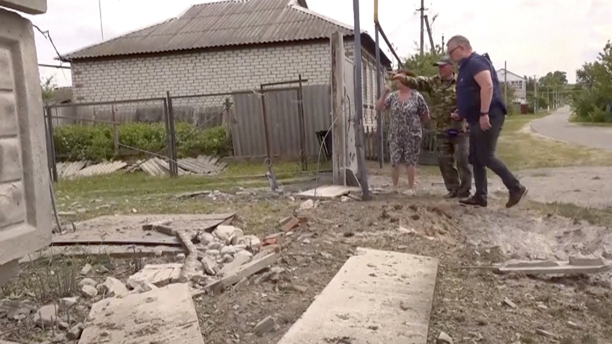 Dieses Bild aus einem Video zeigt Menschen, die auf ein beschädigtes Gebäude in der Region Belgorod hinweisen.