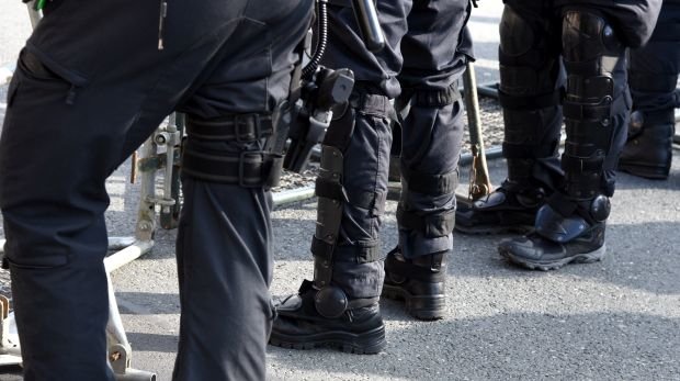 Polizisten in schwarzer Uniform und voller Ausrüstung im Einsatz auf einer Demo