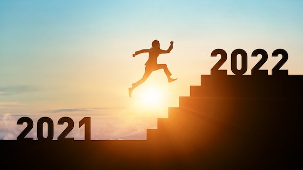 Mensch überspringt Treppenstufen zwischen den Jahreszahlen 2021 und 2022