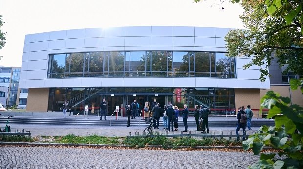 Vor der Freien Universität Berlin, in der wegen des Andrangs verhandelt wird, stehen Menschen in einer Schlange.