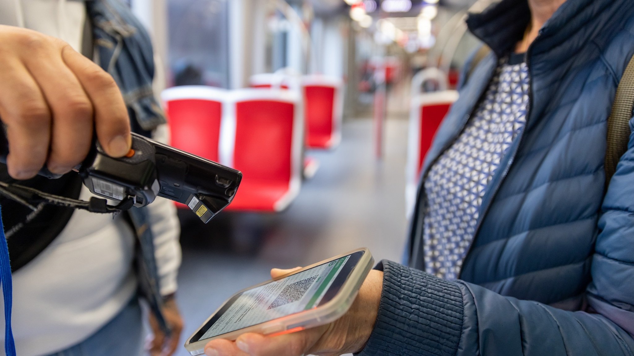 Ein Fahrkartenkontrolleur kontrolliert mit einem elektronischen Lesegerät in der U-Bahn der VAG (Verkehrs-Aktiengesellschaft Nürnberg), den elektronischen Fahrschein von einem Fahrgast (gestellte Szene).