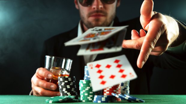Mann wirft beim Poker Karten auf den Tisch