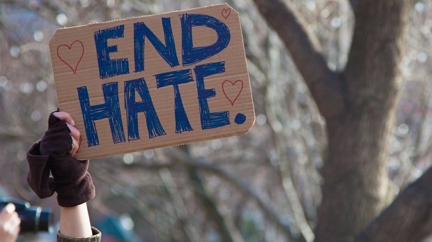 Demonstrant mit Schild gegen Hate Speech