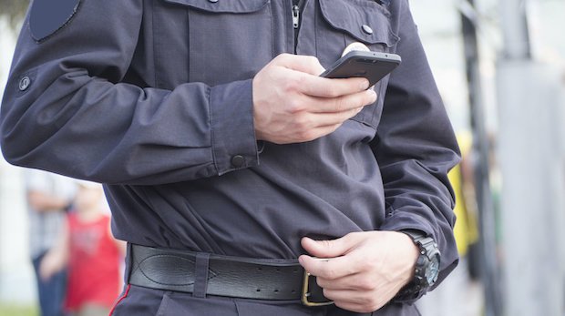 Ein Polizeibeamter nutzt sein Smartphone