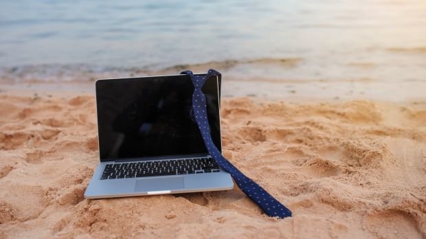 Computer und Krawatte am Strand